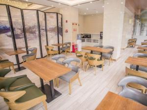 a restaurant with tables and chairs in a room at GreenTree Inn Zhongshan West District Fuhua Road Branch in Zhongshan