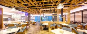 a restaurant with tables and chairs and a cafeteria at Ueasy Hotel The Mixc in Nanning