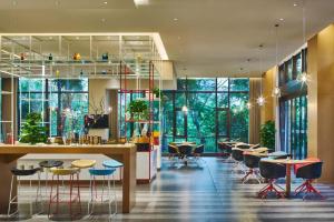 a lobby with tables and chairs and windows at Four Points by Sheraton Haikou International Airport in Haikou
