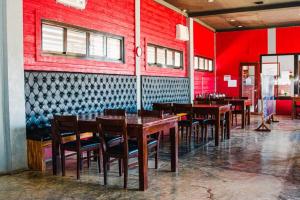 a dining room with red walls and wooden tables and chairs at Sabine's Place in Cangbaliguia