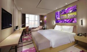 une chambre d'hôtel avec un grand lit et un bureau dans l'établissement Lavande Hotel Wuhan East Lake Xudong Metro Station, à Wuhan