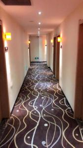 a hallway of a hotel with a patterned floor at 7 Days Premium·Yichang CBD Business Center in Yichang