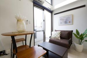 a living room with a couch and a table at Isole le Olena 4F in Naha