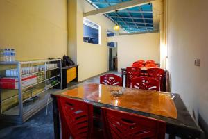 una sala da pranzo con sedie rosse e un tavolo di OYO 1720 A2b Residence a Manado