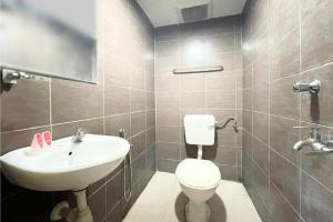 a bathroom with a toilet and a sink at OYO 90324 Muar Station Hotel in Pantai Cenang +51 photos