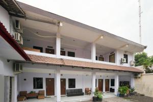 a white house with a red roof at OYO 2003 Female Guest House in Probolinggo