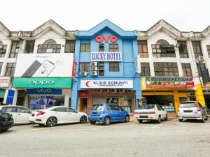 eine Gruppe von Autos, die vor einem Gebäude geparkt sind in der Unterkunft OYO 89406 Lucky Budget Hotel in Kampong Mahang
