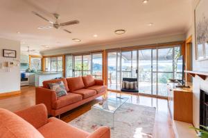 a living room with a couch and a table at Bay and Beachside Family Retreat in Killcare