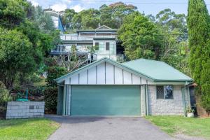 a house with a garage in front of it at Bay and Beachside Family Retreat in Killcare