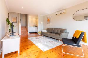 a living room with a couch and a table at Bay and Beachside Family Retreat in Killcare +26 photos