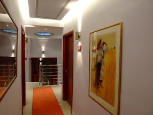 a hallway with a painting on the wall and an orange rug at Hotel Avra in Kardítsa