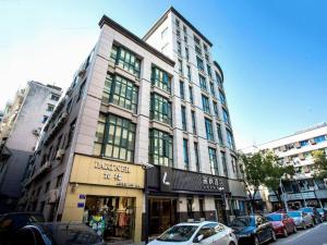 a tall building on a city street with cars parked at Lavande Hotel Jiande Xin'an River in Thousand Island Lake