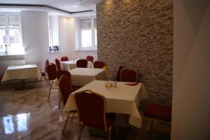 a restaurant with tables and chairs and a brick wall at Villa Amadea in Międzyzdroje