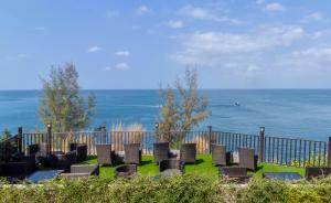皮皮岛Phi Phi Holiday Resort, Leam Tong Beach的一群椅子坐在靠近海洋的草地上