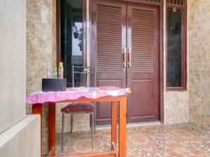 a table in front of a door with a pink table at Hotel O Nakula Sadewa in Areman