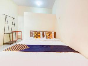 a white bedroom with a bed with pillows on it at Hotel O Nakula Sadewa in Areman