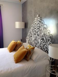 a bedroom with a white bed with yellow pillows at Vivenda Brito in Carvoeiro