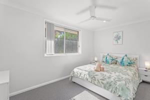 Una habitación blanca con una cama y una ventana en Seaside Sanctuary I Spacious Getaway in Forster, en Forster 9 fotos más
