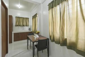 a dining room with a table and a kitchen at OYO 736 Jade Apartelle in Calamba