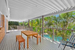porche con mesa de madera y sillas en la cubierta en Seaside Sanctuary I Spacious Getaway in Forster, en Forster