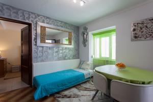 アルブフェイラにあるApartamento Cardosoのベッド、テーブル、鏡が備わる客室です。