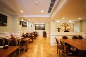 a dining room with wooden tables and chairs at London Hotel in Macau