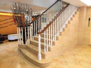 a staircase in a building with a vase of flowers at London Hotel in Macau