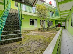 バンドンにあるSPOT ON 91325 Pondok Hijau Guest House Syariahの階段と木がある緑の建物