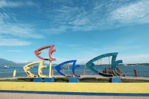 a group ofavyavyulptures on a bench near the water at OYO 880 Flores De Musa Inn in Puerto Princesa City