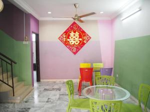 a dining room with a glass table and colorful chairs at OYO Homes 90575 CK Bahau Homestay in Bahau