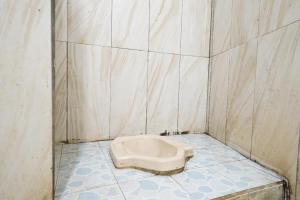 a bathroom with a urinal in the middle of the floor at OYO 91546 Dewi Sudirman Homestay in Bandung +52 photos