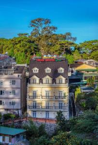 a large white building with a black roof at ADALY Hotel in Xuan An