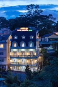 a building with a sign on top of it at night at ADALY Hotel in Xuan An