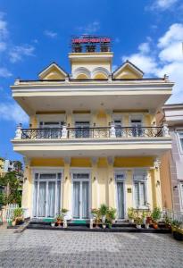 a large yellow building with a balcony on it at ADALY Hotel in Xuan An