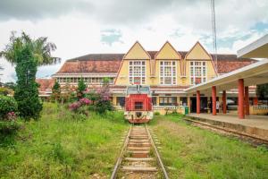 a train on the tracks in front of a building at ADALY Hotel in Xuan An +3 photos