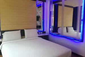 a bedroom with a white bed and a mirror at The Ring Khokmao Hotel in Ban Tha Sae