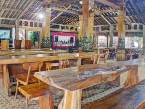 Großes Zimmer mit Holztischen und Stühlen in der Unterkunft Capital O 92681 Randu Mas Hotel & Resort Taman Purbakala in Gedung