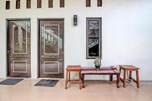 a room with two doors and a table and benches at Hotel O Bagus Jaya Hotel in Semarang