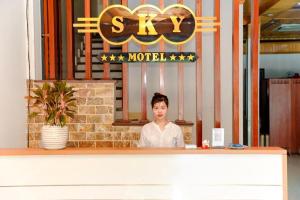 a woman sitting at a counter in a restaurant at SKY HOTEL - KHÁCH SẠN BẮC NINH in Bồ Sơn