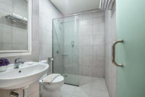 a bathroom with a shower and a toilet and a sink at Life Hotel Soekarno Hatta Makassar in Makassar +85 photos