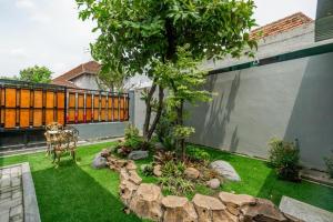 a garden with a tree in the middle of a yard at Homely Syariah in Kediri