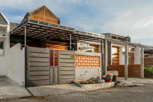 a house with a metal gate and a building at Hotel O Bidara Guest House Syariah in Mojokerto