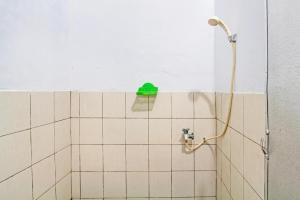 a bathroom with a shower with a green sponge on the wall at SPOT ON 93592 Pondok Backpackers Ardafa Jogja in Manisrenggo