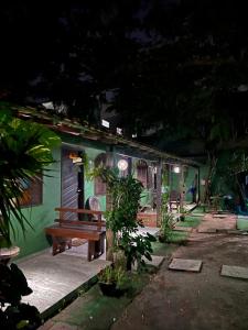 une maison verte avec un banc devant dans l'établissement Suites BrisaMar, à Cabo Frio 18 autres photos