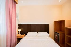 a bedroom with a bed with a black headboard and a desk at JVJ HOTEL in Batangas City