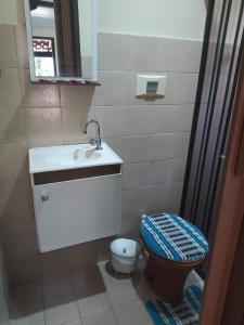 une petite salle de bain avec un lavabo et des toilettes dans l'établissement Suites BrisaMar, à Cabo Frio