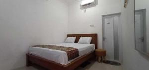 a bedroom with a bed and a walk in shower at Hotel O Homestay Kita Purworejo in Purworejo