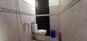 a bathroom with a toilet in a tiled room at Hotel O Homestay Kita Purworejo in Purworejo +26 photos