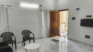 a room with two chairs and a table and a television at Shri Virajita - Budget 1 BHK Double Bed in Gokarna