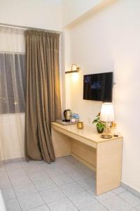 a room with a desk with a lamp and a window at Hotel O Bintang Holiday in Kuala Lumpur